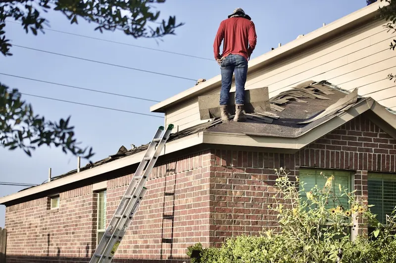 Professional roofer working on a residential roof in Exposition View